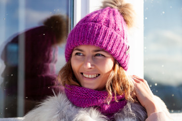 Wall Mural - Portrait beauty woman model on winter background. Beautiful modern  young woman wearing pink knitting hat  warm hands, smile, look away and enjoy on a walk on the frozen winter