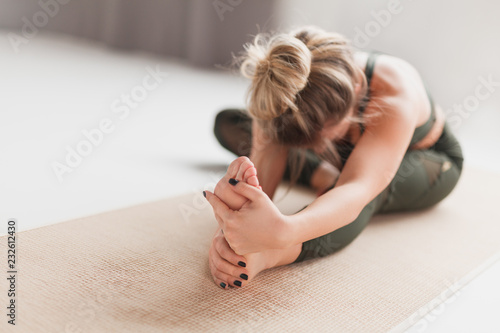 Fotografía Young woman performing Janusirsasana exercise