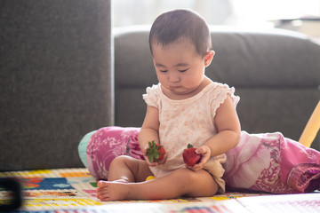 Cute 6 month old baby with strawberries