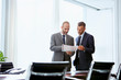 © Stocksy - Businessmen Discussing Over Document In Office