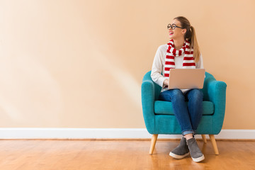 Young woman with a laptop computer in a chair