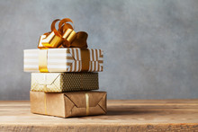 Heap Of Golden Gift Or Present Boxes On Wooden Table. Composition For Birthday Or Christmas.