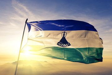 Lesotho Mosotho Basotho flag textile cloth fabric waving on the top sunrise mist fog