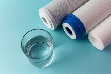 Wall Mural - A glass of water on the background of filter cartridges top view