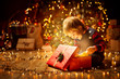 © inarik - Christmas Child Open Present Gift, Happy Baby Boy looking to Magic Light in Box, Kid sitting front of Xmas Tree