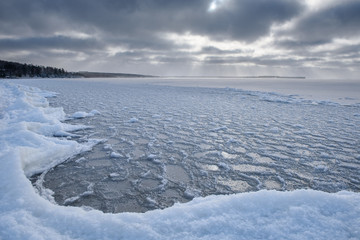 Wall Mural - ice freezes in winter on the surface of a large body of water.
