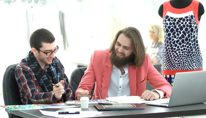 two creative designers discuss new ideas sitting at a table in a creative Studio