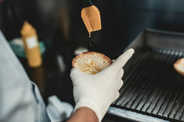 Close up. Worker Cooking Burger in Food Truck.