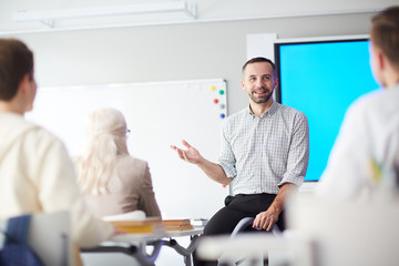 happy confident teacher explaining his students what he thinks about new subject