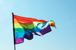 © New Africa - Rainbow gay flag against blue sky. LGBT concept
