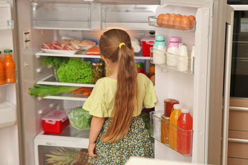 Sticker - Cute little girl choosing food in refrigerator at home