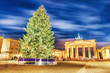 Lovely Christmas Advent night scenery of Brandenburg Gate with Christmas Tree in Berlin, the capital of Germany, Europe. Winter holidays background. Brandenburg Gate is iconic landmark.