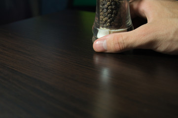 Pepper pot in a hand close up background