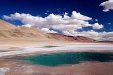 Clouds Over One Of The Deep Blue 'Ojos De Mar' Salt Pools Of Water Containing Ancient Stromatolites In The High Altitude Puna Altiplano Desert Of North West Argentina, Near The Town Of Tolar Grande