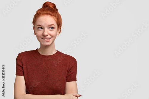 Photo Of Thoughtful Tender Woman Bites Lower Lip Looks With