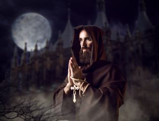 Wall Mural - Medieval monk praying against castle and full moon