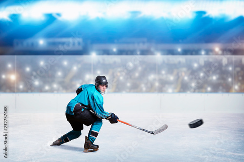 Fototapeta na szkło Hockey player with stick and puck makes a throw