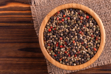 Wall Mural - Mix of peppers in bowl burlap napkin on wooden background