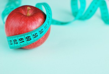 Measure tape and red apple, diet, weight loss concept, place for text.