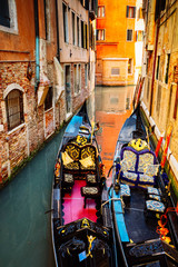 Two venetian gondola boats in the water of a canal, retro toned