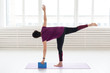 People, yoga, sport and healthcare concept - Middle-aged woman practicing yoga, using stretching cube