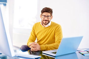 Handsome young man using laptop while working in the office