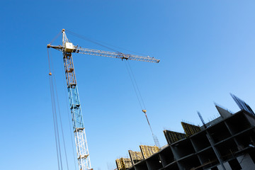 part of the building under construction and the tower crane with the lowered rope on the building