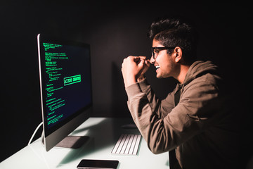 Software developer computer scream of win at dark home office. Startup and hard working concept