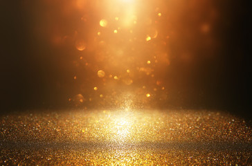 glitter vintage lights background. black and gold. de-focused.