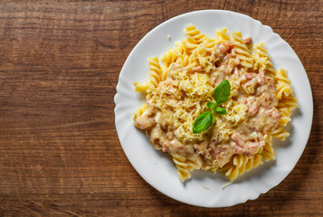 Wall Mural - Fusilli Pasta with Carbonara Sauce and cheese in white plate on wooden table background