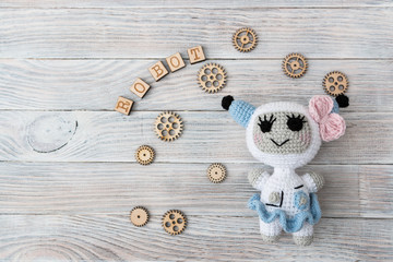 Knitted beautiful robots of white and blue threads. Concept. Needlework. Technology. Handmade. Education. Free space for text. White background.