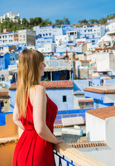 Wall Mural - The blue pearl, Chefchaouen, called in this way for the colorful medina, with a nice pale model in a red dress, North of Morocco. Model in an Oriental Landscape.