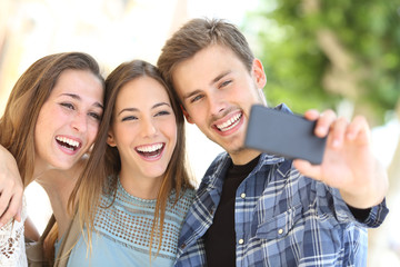 Sticker - Three happy friends taking selfie together in the street