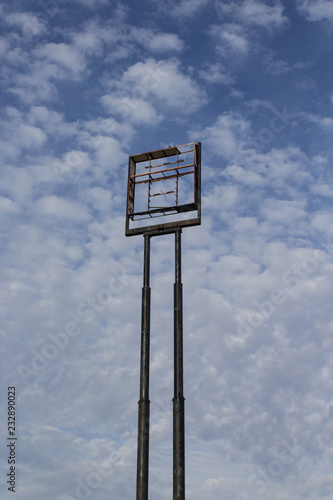 Fotografie, Obraz Tall empty highway sign frame against a blue sky with clouds, centered, copy spa