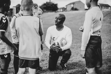 Canvas Print - Football coach instructing his students