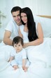 © ASDF - Cute little boy with parents on the bed