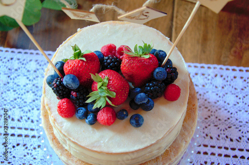 A Vanilla Wedding Cake Decorated With Strawberries Blueberries