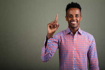 Wall Mural - Young handsome African businessman against colored background