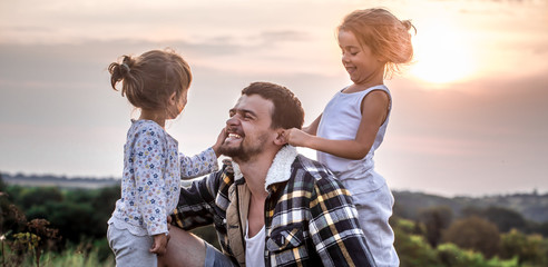 dad playing with two little cute daughters