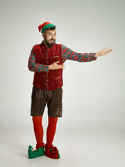 friendly man dressed like a funny gnome posing on an isolated gray background