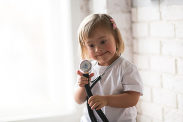 Toddler with Down syndrome plays with stethoscope