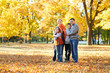 © soleg - Happy family walks in autumn city park. Children and parents posing, smiling, playing and having fun. Bright yellow trees.