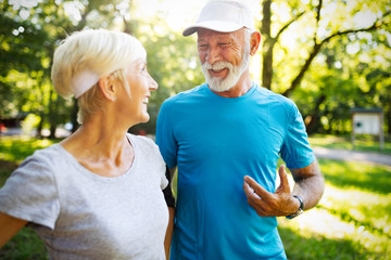 Mature couple jogging and running outdoors in city