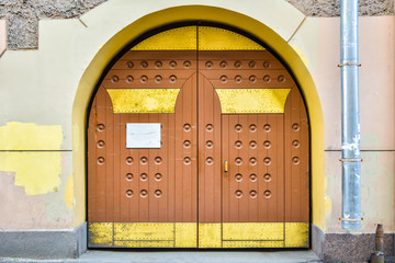 Wall Mural - Closed grunge brown wood old door with decorative gold metal plates