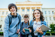 © Iryna - Low angle view of three defferent age students on university campus in autumn time.