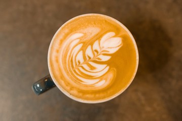 Top view, latte art, cup of coffee on the gray stone tabletop