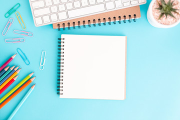 Wall Mural - blank notebook with keyboard and pencil on blue background,flat lay photo of notebook for your messa
