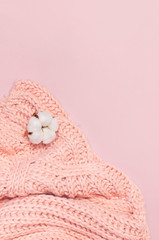 Wall Mural - Female pink knitted sweater pullover and flower of cotton on pastel pink background top view flat lay. Fashion Lady Clothes Jumper Autumn winter clothes fashion look Delicate cotton flowers Lifestyle