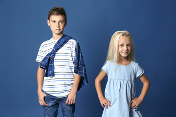 Poster - Cute boy and girl in fashionable clothes on color background