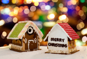 cooking, holidays and bakery concept - gingerbread houses over christmas lights background